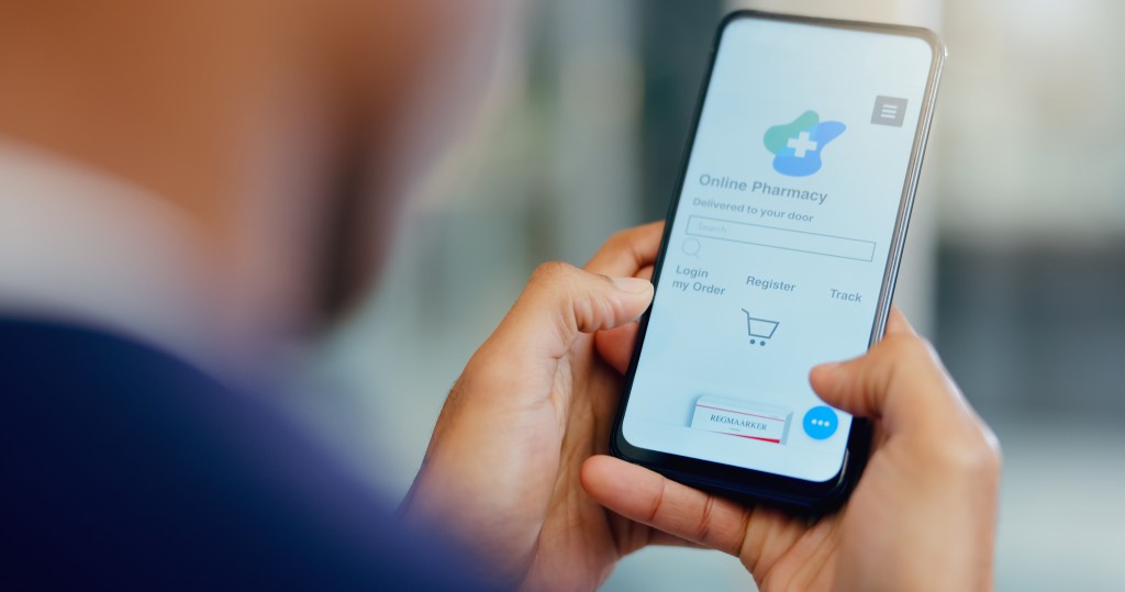 Man scrolling on mobile to order vitamins or pills from one "online pharmacy."